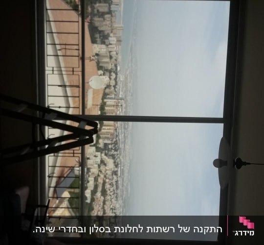 חלון עם מסגרת אלומיניום ונוף עירוני